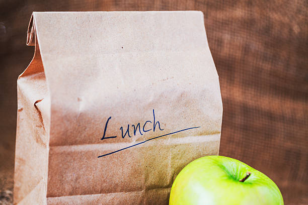 Brown bag lunch with apple stock photo