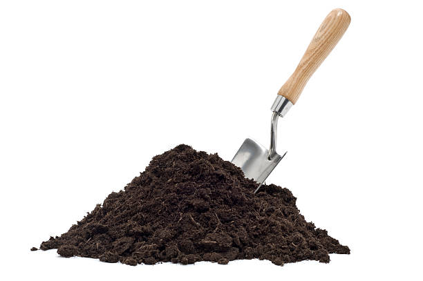 Brown compost pile with a spade on top stock photo