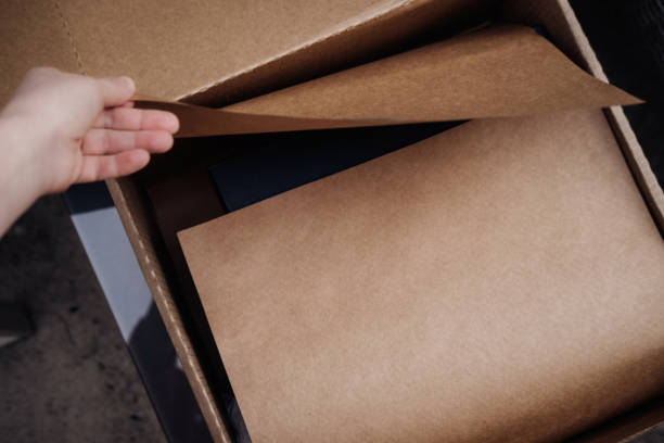 bruine open doos met ambachtelijk inpakpapier - unbox stockfoto's en -beelden