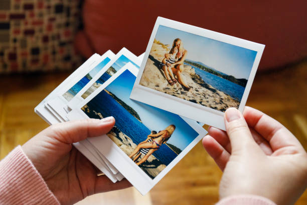 browsing vacation photographs at home - a closeup - ver fotografias imagens e fotografias de stock