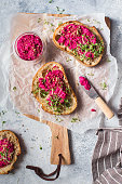 Bruschetta with Beetroot hummus decorated with chopped nuts and microgreen. Vegan recipes, plant-based dishes. Green living concept. Organic food. Vegetarian cuisine. Bread with pink dipping sauce