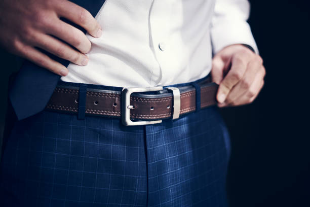 Buckle up, you're about to get married Cropped shot of a man wearing a belt with his jeans and shirt on his wedding day pants stock pictures, royalty-free photos & images