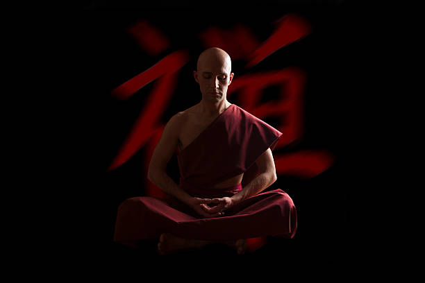 黒い背景の上に瞑想ポーズで仏教僧 - 座禅 ストックフォトと画像