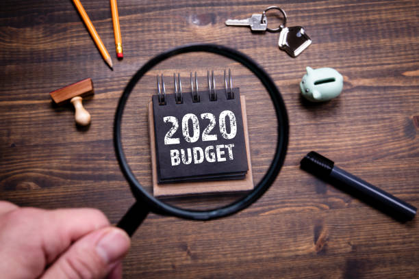 2020 Budget, family finances, economics, trade and career concept 2020 Budget, family finances, economics, trade and career concept. Man's hand, holding magnifying glass home finances stock pictures, royalty-free photos & images