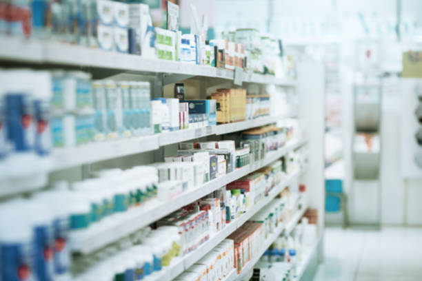 Bidikan rak yang diisi dengan berbagai produk obat di apotek