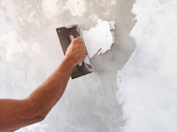Builder using plastering tool for finishing old wall. stock photo
