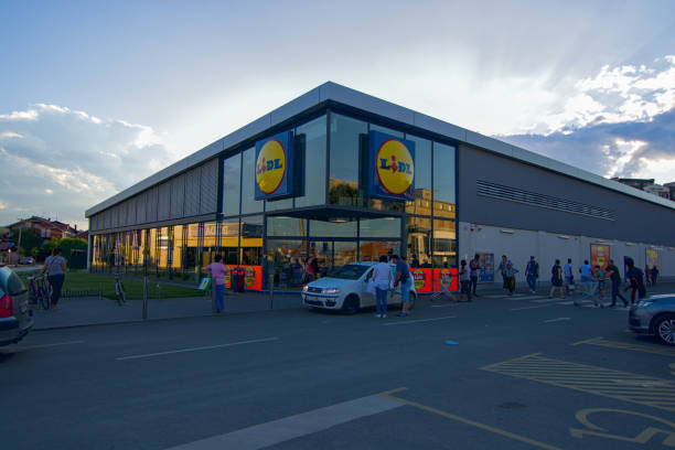 Building of Lidl supermarket Cars move in the parking lot in front of the entrance to the Lidl supermarket building lidl stock pictures, royalty-free photos & images