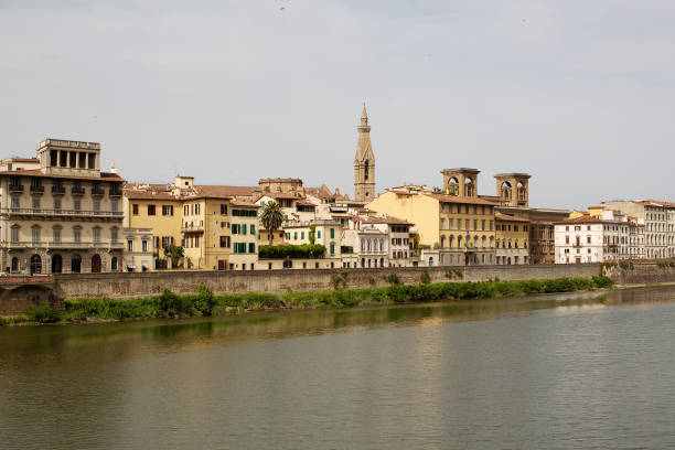 Buildings along the Arno River Florence Florence, Italy, June 15, 2019:Historic buildings reflecting the Arno River, Florence, Italy, in warm late afternoon sunlight arno river stock pictures, royalty-free photos & images