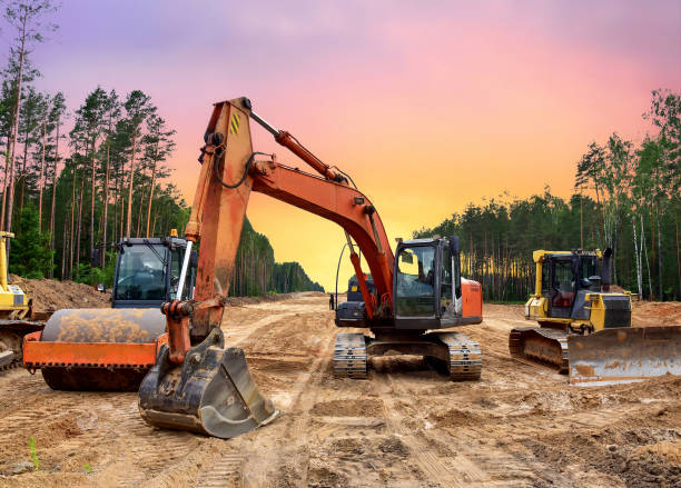 Bulldozer, Excavator and Soil compactor on road work. Earth-moving heavy equipment and Construction machinery during land clearing, grading, pool excavation, utility trenching and digging stock photo