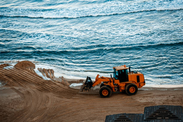 Bulldozer flattening out surface of the beach Bulldozer flattening out surface of the beach public service stock pictures, royalty-free photos & images