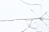 istock Bullet hole in broken glass on a white background. Shards of glass 1351888157