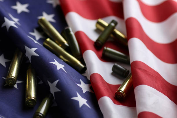 bullet on the USA flag many shell casings from bullets of different caliber in the background chaos concept in the world bills patriots stock pictures, royalty-free photos & images