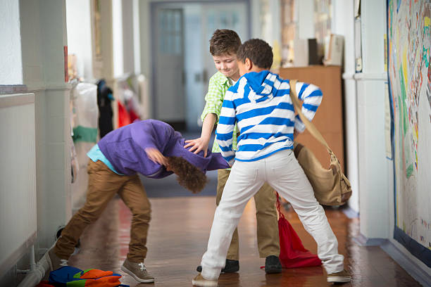 Bullying In The School Corridor Young Boys fighting in the School corridor bullying stock pictures, royalty-free photos & images