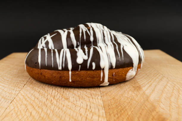 bun covered with chocolate, on a wooden board stock photo