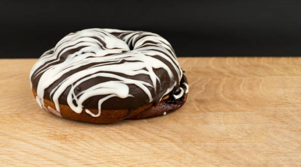 bun covered with chocolate, on a wooden board stock photo