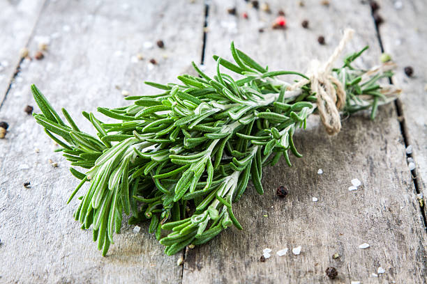 bunch of fresh rosemary a bunch of fresh rosemary on a wooden background thyme photos stock pictures, royalty-free photos & images