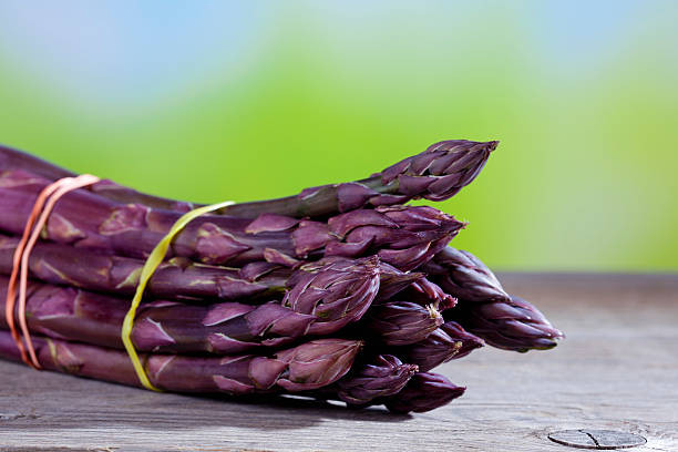 Bunch of violet asparagus on wood stock photo