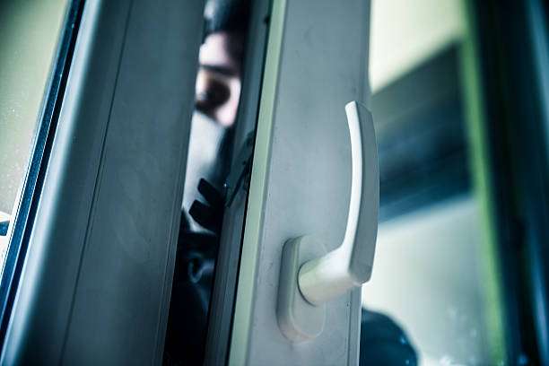 Burglar breaks into a residential building Burglar breaks into a residential building. burglary stock pictures, royalty-free photos & images