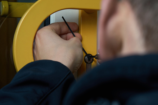 Burglar With Lockpick Tool Opens The Front Door To Enter The House