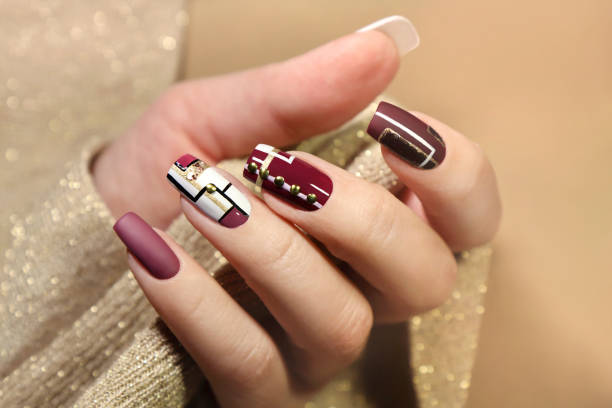 Burgundy and white design on long nails stock photo