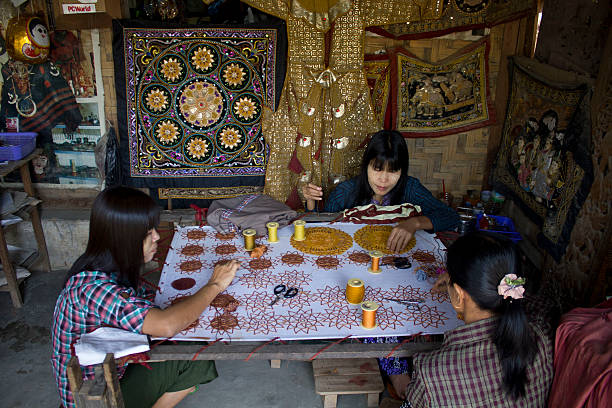 Burmese woman at work sewing beads. stock photo