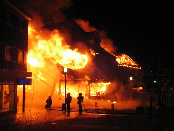 Burning building Building in full flaming inferno, and the firefighters fighting to get control of the flames fire natural phenomenon stock pictures, royalty-free photos & images