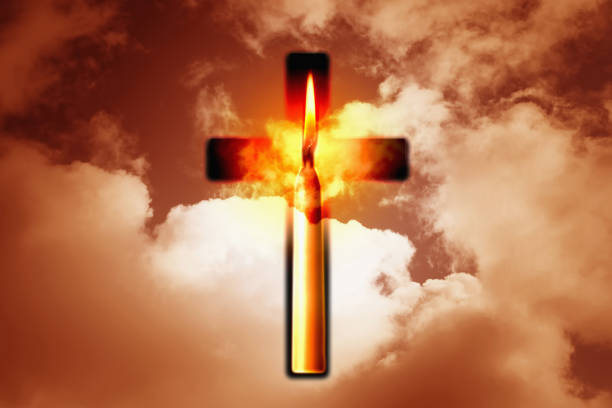Burning candle and Christian cross against the sky. Concept of spirituality and faith in jesus christ stock photo