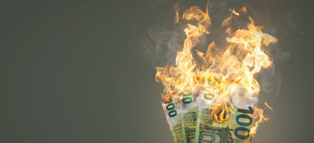 Burning money - 100 Euro banknotes on fire 100 Euro banknotes burning with bright flames. Copy space to the left. inflation stock pictures, royalty-free photos & images