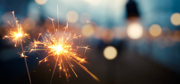 Burning sparkler with bokeh light background Burning sparkler with bokeh light background sparkler firework stock pictures, royalty-free photos & images