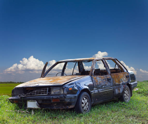 Burnt car in rural Thailand. A car accidentally burned in the car due to an accident on the lawn in rural Thailand with a backdrop of clouds. obsolete stock pictures, royalty-free photos & images
