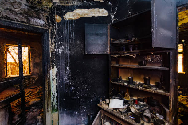 Burnt house interior. Burned furniture, kitchen cabinet, charred walls and ceiling in black soot stock photo