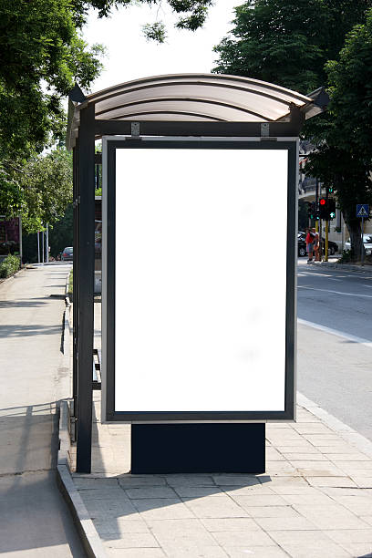 Bus shelter on the side of the street on a sunny day This is for advertisers to place ad copy samples on a bus shelter billboard posting stock pictures, royalty-free photos & images
