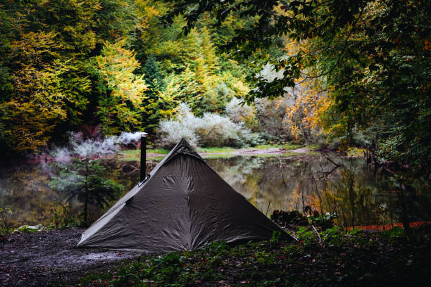 Bushcraft tent with stove in the lakeside Camping in the wilderness in the National Forest in the fall bushcraft stock pictures, royalty-free photos & images