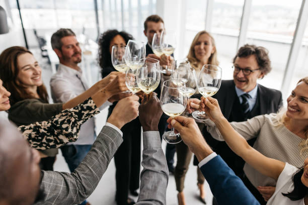 Business colleagues giving a toast at work stock photo