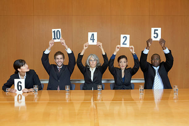 Business colleagues holding up cards with numbers  judgement stock pictures, royalty-free photos & images
