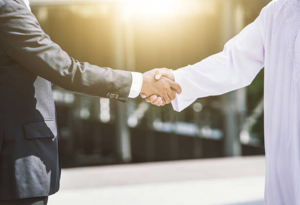 Business handshake concept. shaking hand of two businessman closing a deal city background Business handshake concept. shaking hand of two businessman closing a deal city background arab culture stock pictures, royalty-free photos & images