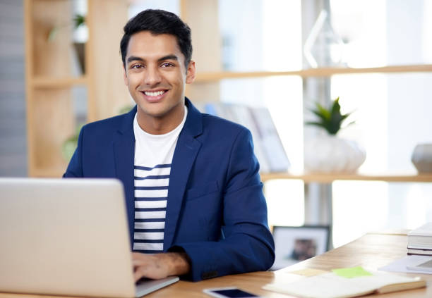 Business has been picking up well under his leadership Portrait of a handsome young businessman working in an office indian ethnicity stock pictures, royalty-free photos & images