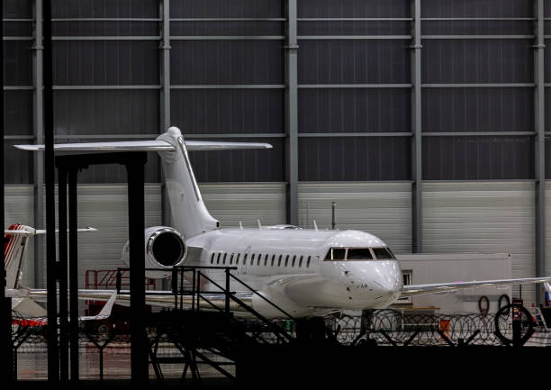 Business jet in an aircraft hangar of a maintenance company at Nuremberg airport at night stock photo