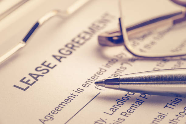 Business legal document concept : Pen and glasses on a lease agreement form. Lease agreement is a contract between a lessor and a lessee that allow lessee rights to use of a property owned by lessor  Rent to Own stock pictures, royalty-free photos & images