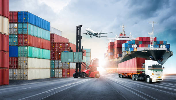 劇的な青空、物流輸入輸出、輸送業界の背景にある造船所におけるコンテナ貨物船と貨物機のビジネスロジスティクスと輸送コンセプト - 物流 ストックフォトと画像