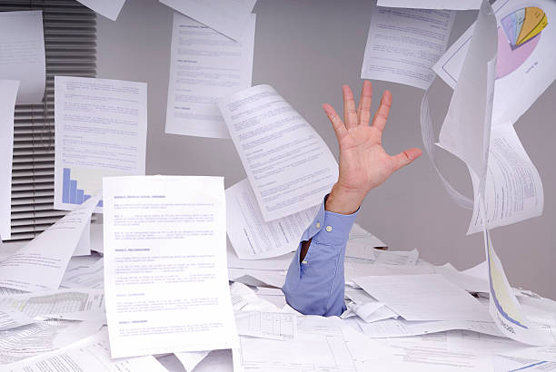 Business man drowning in paperwork stock photo