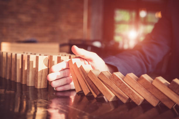 Business man placing wooden block on a tower concept risk control, Planning and strategy in business.Alternative risk concept,Risk To Make Buiness Growth Concept With Wooden Blocks stock photo