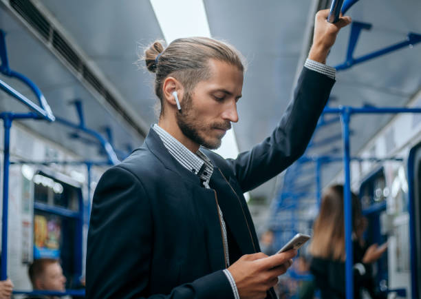 地下鉄で電子メールの通信を読んでいるビジネスマン - 電車　音楽 ストックフォトと画像