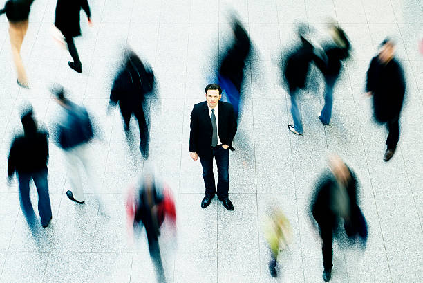 Business man surrounded by people stock photo