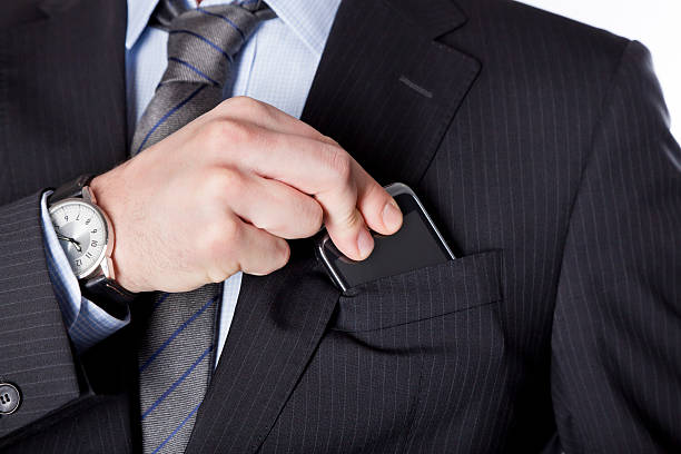Business man taking the smartphone out of his pocket stock photo
