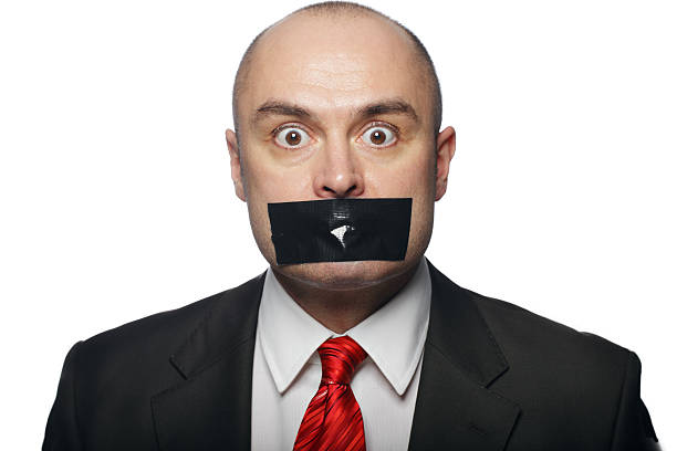 business man with tape over mouth - plakband mond stockfoto's en -beelden