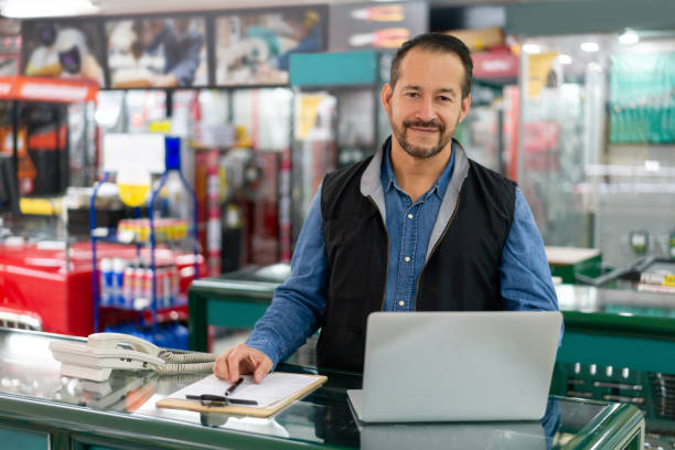business manager looking happy working at a hardware store - balcão computador imagens e fotografias de stock