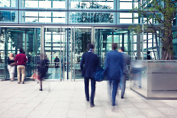 business people entering and leaving office building, motion blur - betreden stockfoto's en -beelden