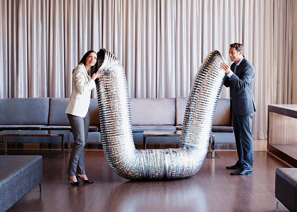 Business people holding metal tubing in hotel lobby  active listening stock pictures, royalty-free photos & images