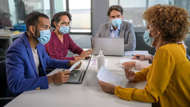 Business people wearing protective face masks at work stock photo